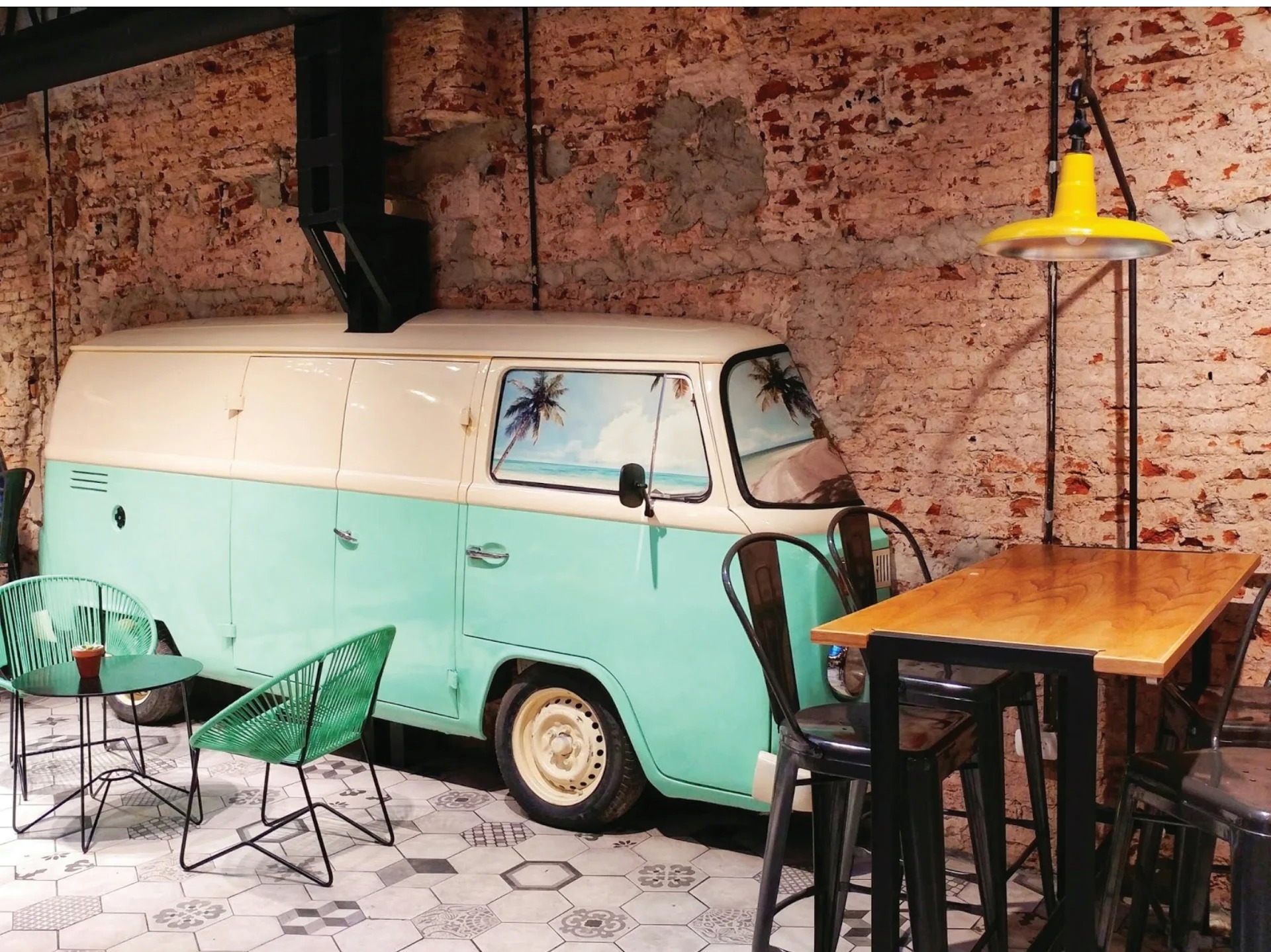 Green Eat vintage VW van installation, exposed brick, yellow pendant, black iron tables