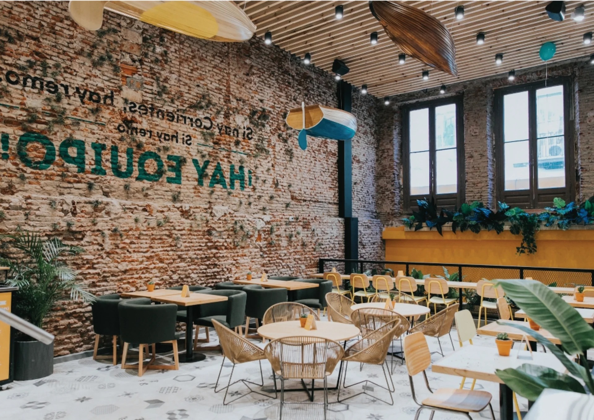 Green Eat flagship dining room, exposed brick, rattan pendants, botanical seating zones